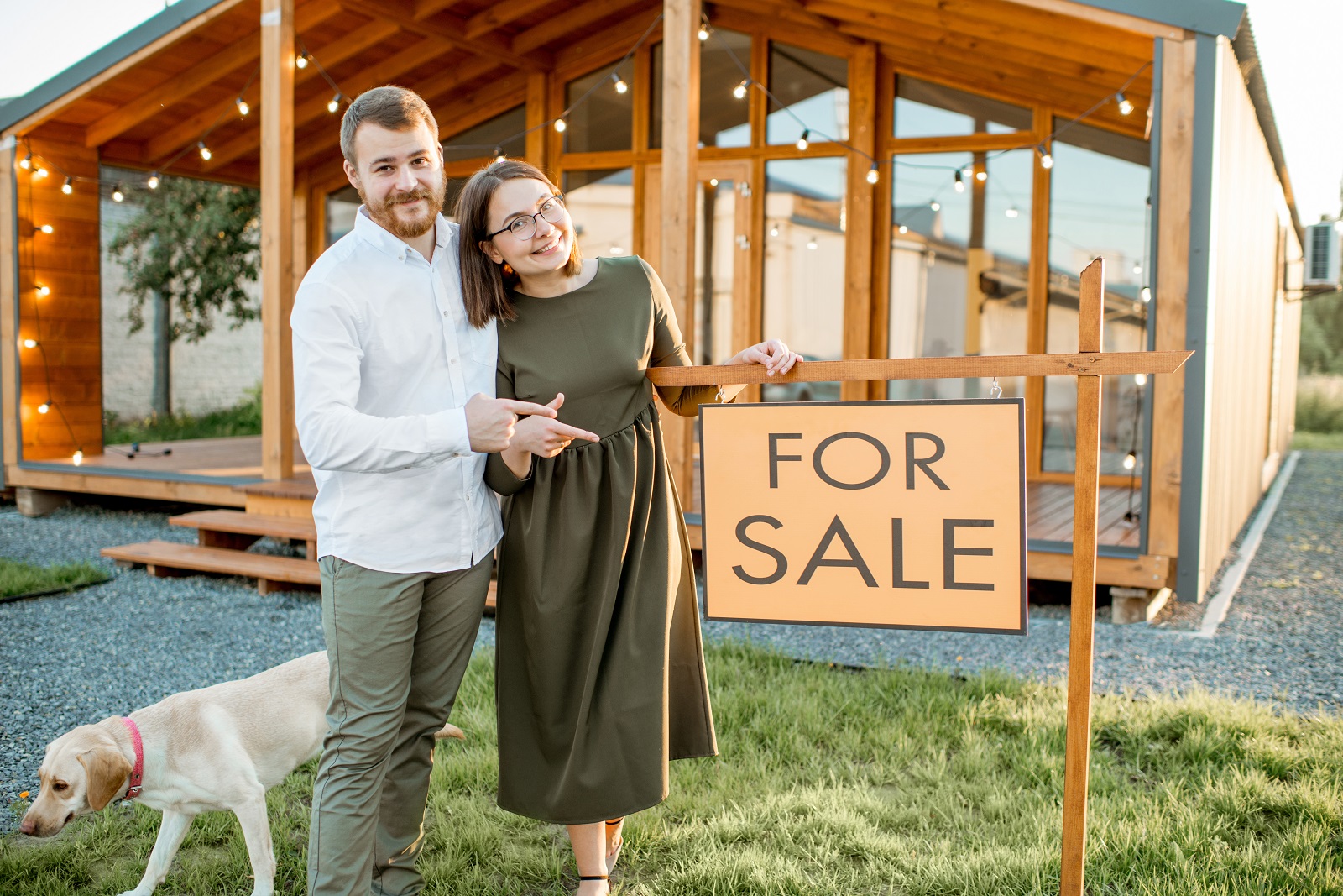 Couple with Dog by Home For Sale Sign