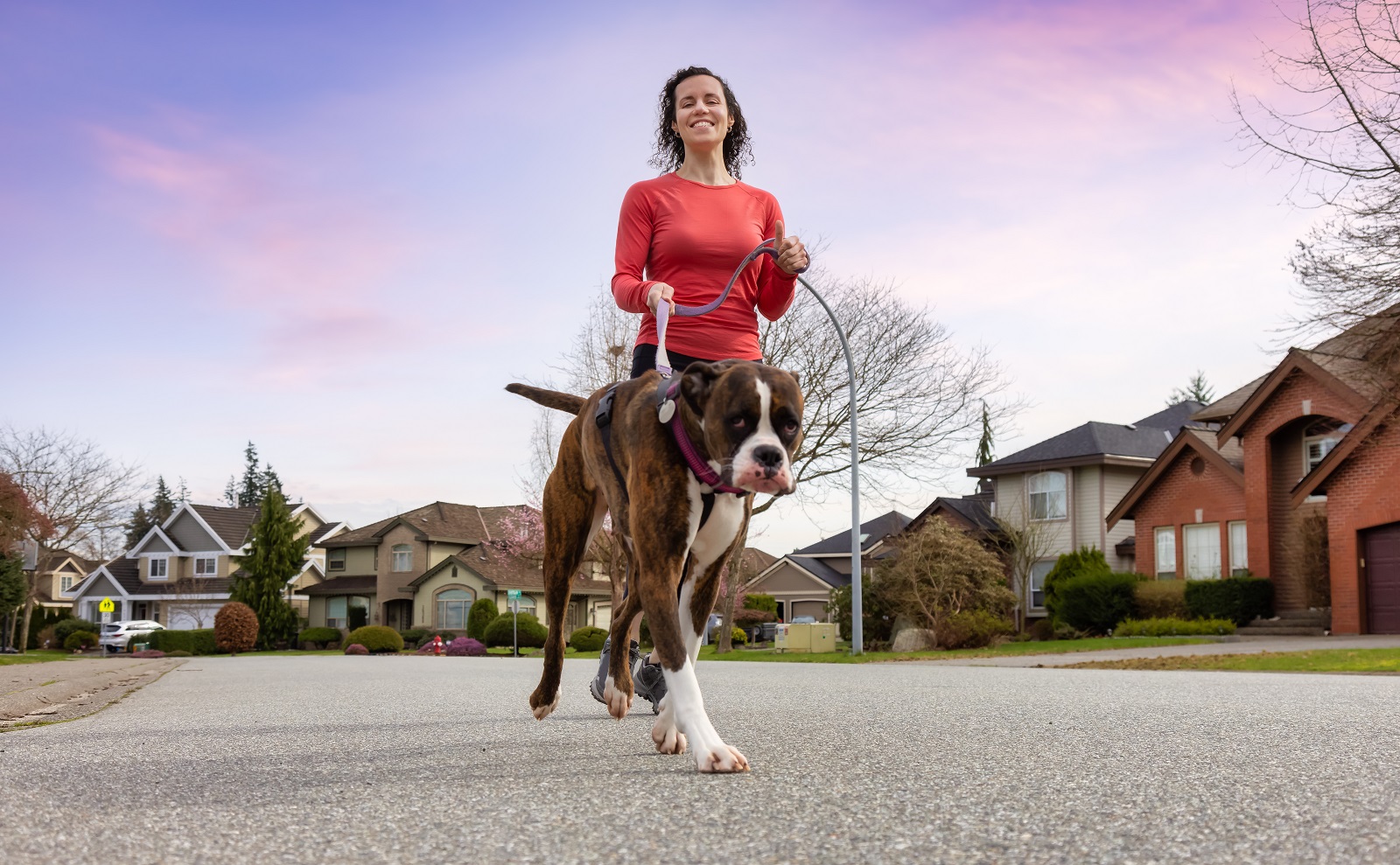 Woman running with her dog through the neighborhood